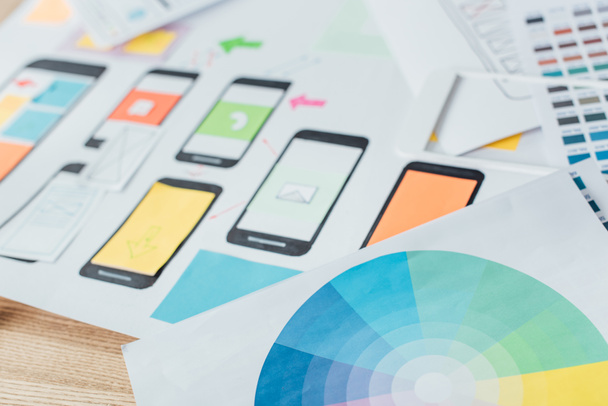 Επιλεκτική εστίαση του κύκλου χρωμάτων και προτύπων με το σχεδιασμό της ιστοσελίδας για κινητά σε ξύλινο τραπέζι - Φωτογραφία, εικόνα
