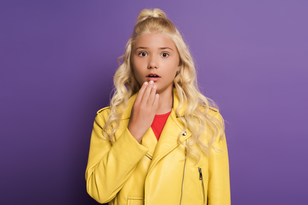 shocked and cute kid looking at camera on purple background  - Photo, Image