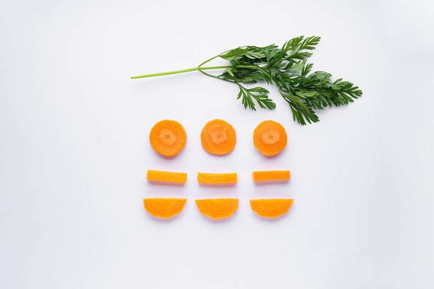Flat lay composition with fresh slices and a branch from carrots on a white background - Foto, immagini