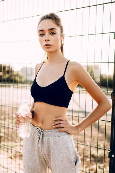 Sporty young girl outdoors holding water bottle. after a workout - Fotografie, Obrázek