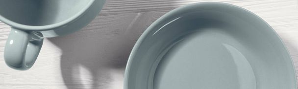Top view of empty blue ceramic plate and mug on white wooden background - Valokuva, kuva