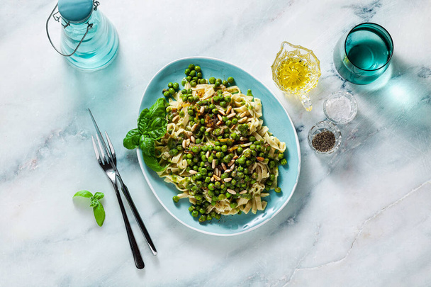 spring homemade Italian pasta with chickpea flour and pesto with fresh green peas and pine nuts. delicious mediterranean cuisine - Fotó, kép