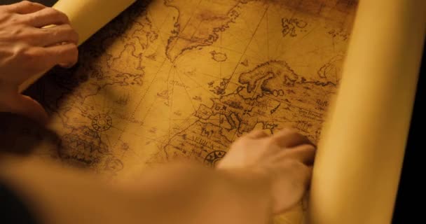 ruce otevírají válcovanou mapu starého světa - Záběry, video