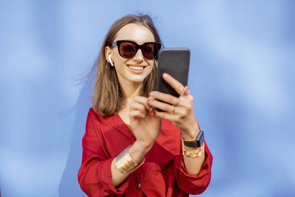 Женщина с телефоном на цветном фоне на открытом воздухе
 - Фото, изображение