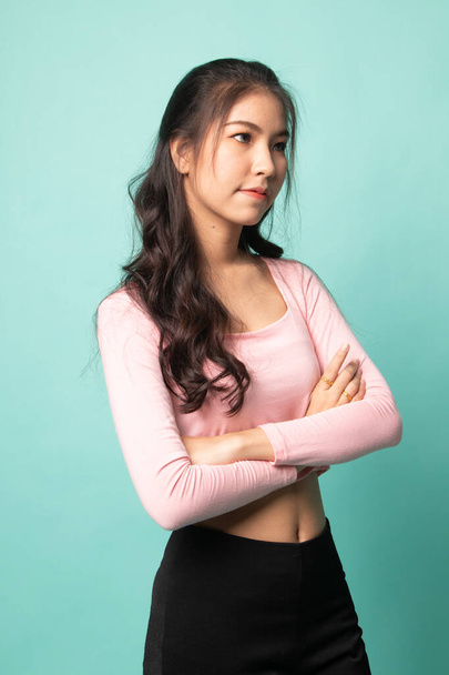 Portrait of beautiful young Asian woman on cyan background - Φωτογραφία, εικόνα