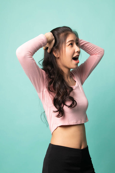 Stressed young Asian businesswoman scream out on cyan background - Foto, imagen