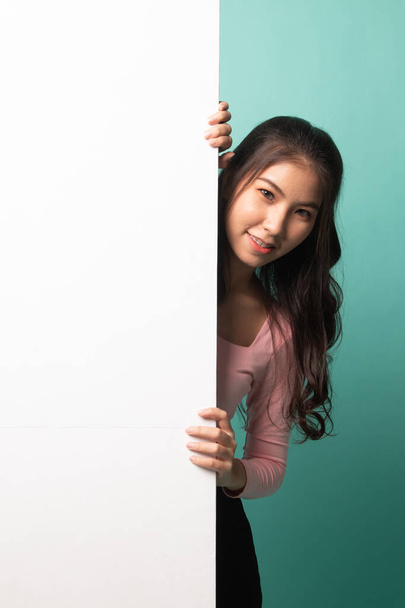 Young Asian woman with blank sign on cyan background - Foto, immagini