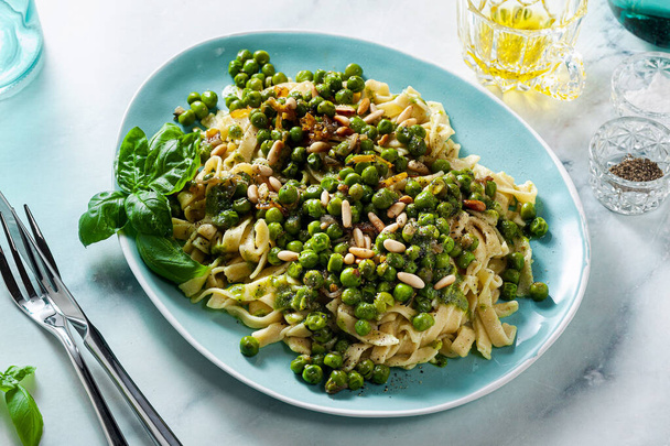 spring homemade Italian pasta with chickpea flour and pesto with fresh green peas and pine nuts. delicious mediterranean cuisine - Fotografie, Obrázek