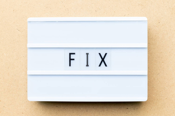 White lightbox with word fix on wood background - Foto, Bild
