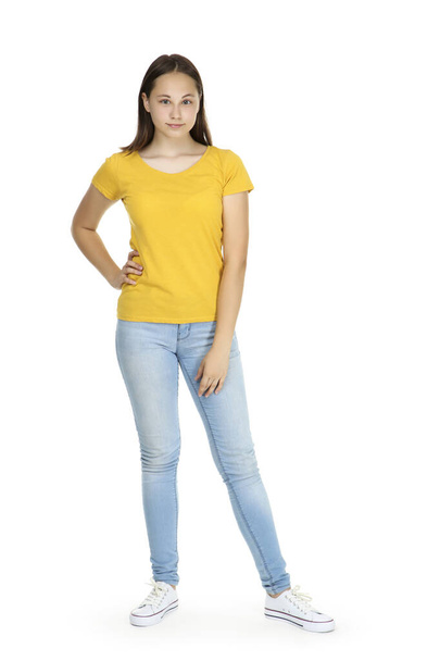 Young girl in yellow t-shirt and blue jeans isolated on white background - Φωτογραφία, εικόνα