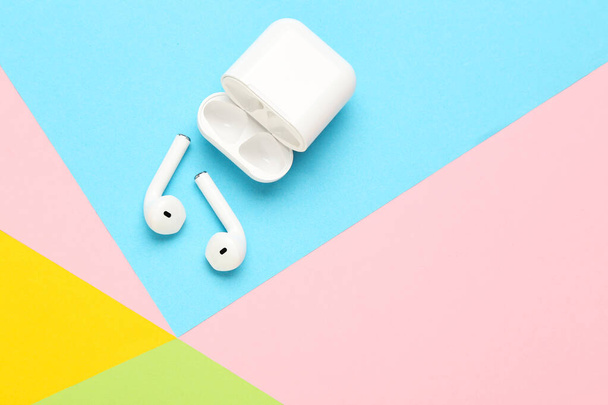 White wireless earphones on colorful paper background - Photo, image