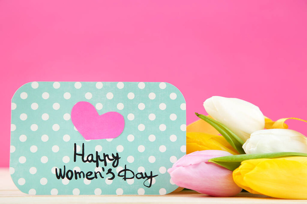 Text Happy Womens Day with tulip flowers on pink background - Foto, Imagem