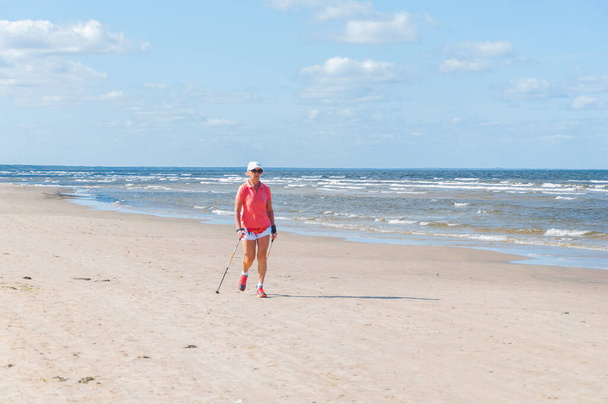 Elderly lady walking on sandy beach at Baltic Sea - Foto, Imagem