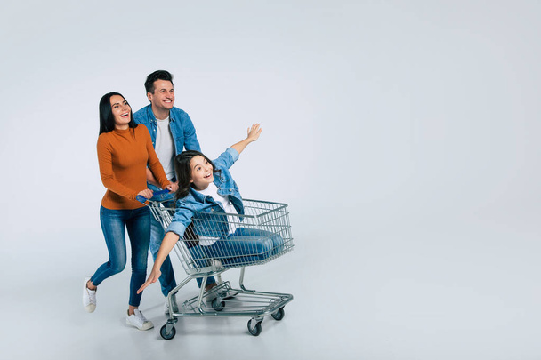 happy family with shopping cart and bags on white background - Photo, image