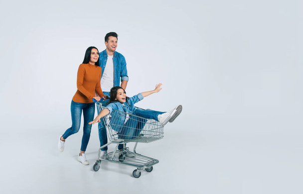 happy family with shopping cart on white background - Foto, imagen