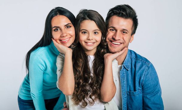 familia feliz con hija sobre fondo gris
 - Foto, Imagen