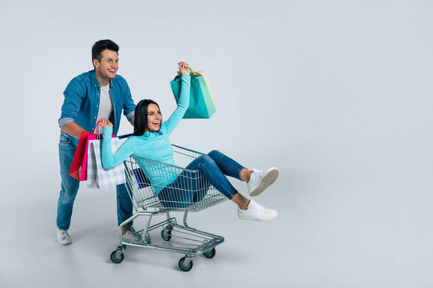 young couple with shopping bags on white background - Zdjęcie, obraz