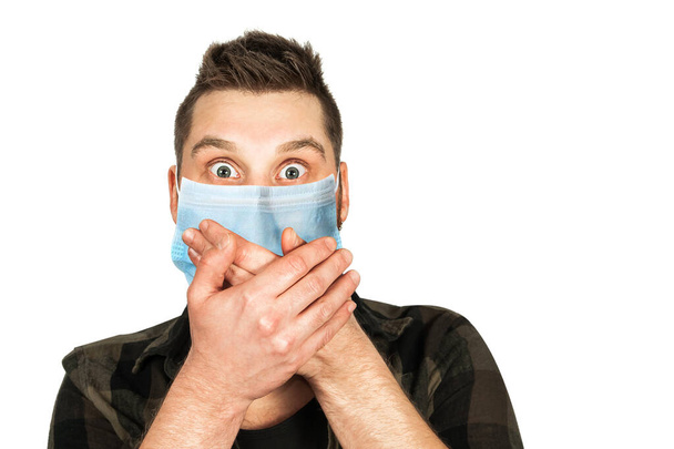 Sick young man with a surprised look in a medical mask. Virus protection during an influenza epidemic. corona virus disease 2019 - Φωτογραφία, εικόνα