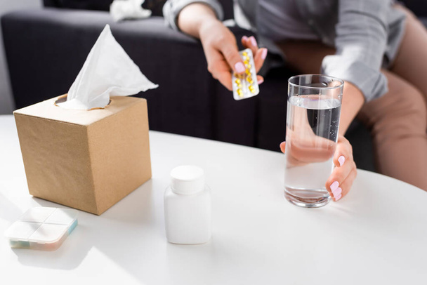 cropped view of allergic woman holding blister pack with pills and glass of water  - Foto, Imagem