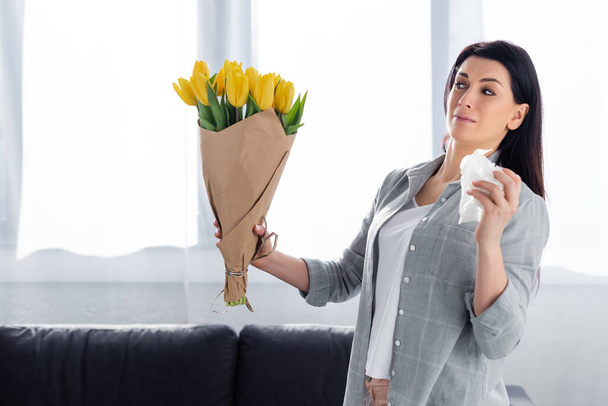 verängstigte Frau mit Pollenallergie beim Anblick von Tulpen  - Foto, Bild