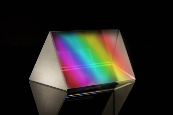 Треугольная оптическая призма для научных экспериментов изолирована на черном отражательном фоне
 - Фото, изображение