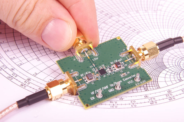 Ingeniero de radiofrecuencia inspeccionar mezclador de microondas placa de circuito impreso PCB delante de Smith gráfico
 - Foto, Imagen