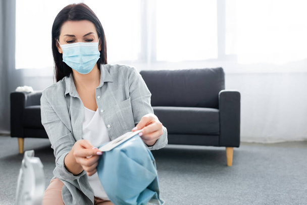 enfoque selectivo de la mujer alérgica en la máscara médica que sostiene la bolsa de polvo
  - Foto, Imagen