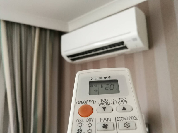 Remote control setting temperature for air conditioner on the wall - Photo, Image