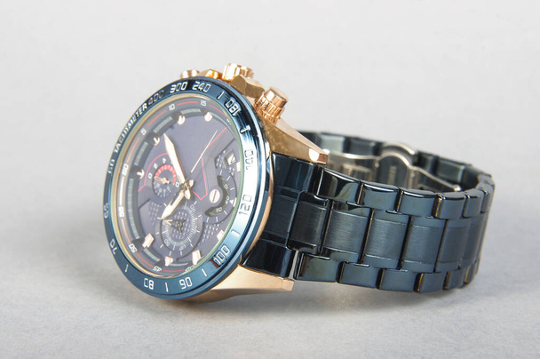 Professionelle Luxus goldblaue männliche Uhr auf der grauen Oberfläche - Foto, Bild