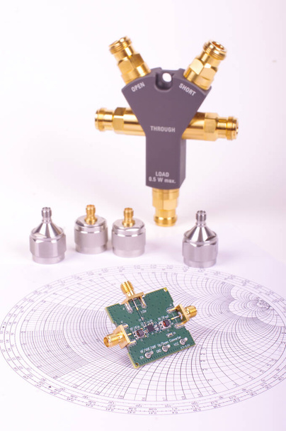 Hochfrequenz-Mixer-Leiterplatte vor Smith-Diagramm und anderen Mikrowellen-Messgeräten - Foto, Bild