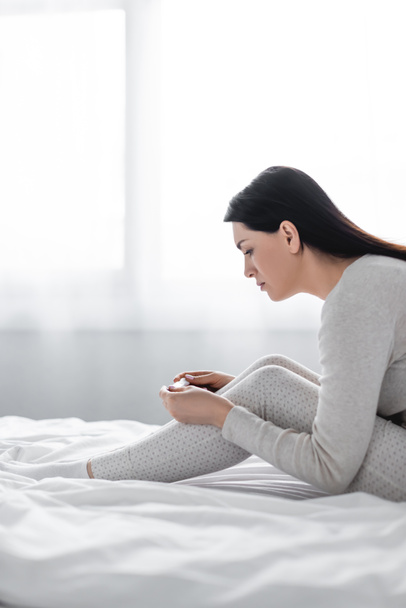 陰性の結果で妊娠検査をしているうつ状態の女性の側図  - 写真・画像