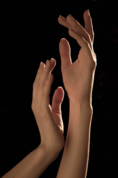 Η χαριτωμένη καμπύλη των χεριών της μπαλαρίνας, σε μαύρο φόντο - Φωτογραφία, εικόνα