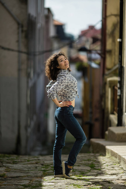 A mixed-race woman full-length portrait on a street in the old city.  - Foto, imagen
