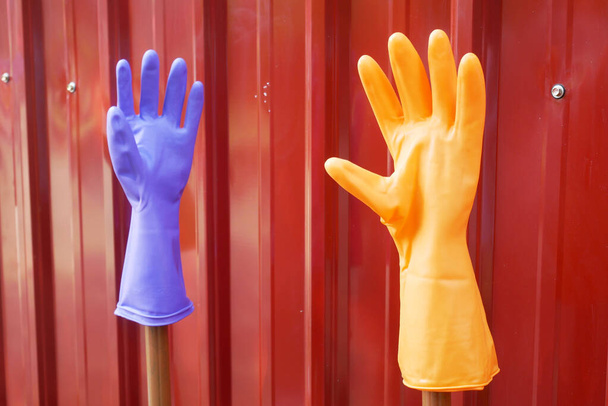 Πολύχρωμα γάντια χειρός από καουτσούκ με κόκκινο φόντο - Φωτογραφία, εικόνα