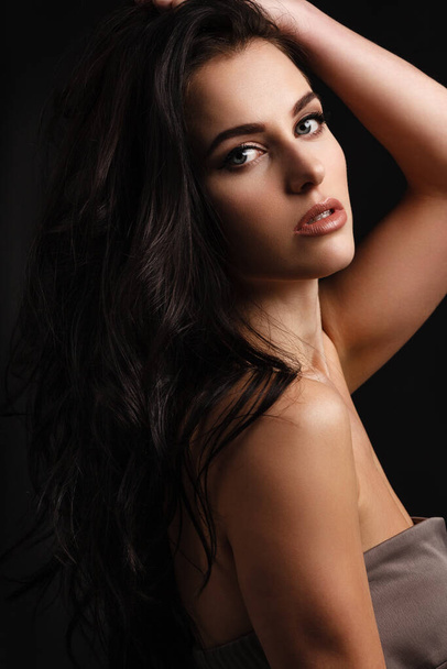 portrait of a young lady with beautiful brunette hair on dark - Photo, Image