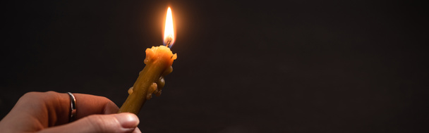 vista cortada da mulher segurando vela da igreja em chamas no escuro, tiro panorâmico
 - Foto, Imagem