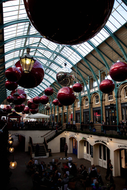 giant christmas baubles hung from the roof of Covent Garden in London - Photo, Image