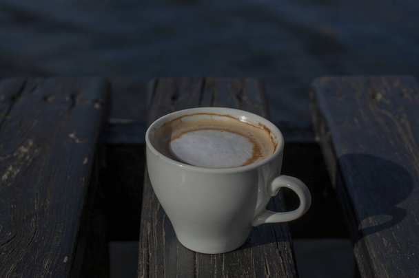 A kávé szelektív fókusz. Fehér csésze cappuccino a természetben. Fehér csésze cappuccino, kávé, reggel, vidámság. - Fotó, kép