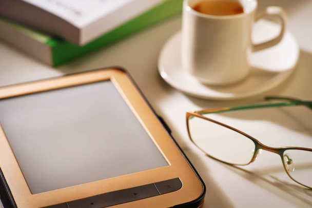 E-reader with cup of coffee and glasses, concept - Foto, imagen