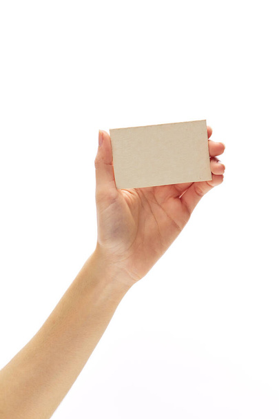 asian female hand holds white empty paper card on a white background. - Foto, afbeelding