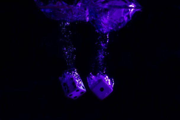Kocka fröccsenő le kék megvilágított vízben. - Fotó, kép