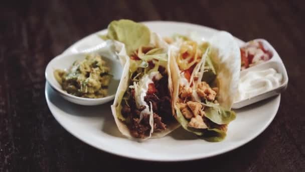 Chicken and cheese and beef tacos served with guacamole, pico de gallo and sour cream dip - video in slow motion - Footage, Video