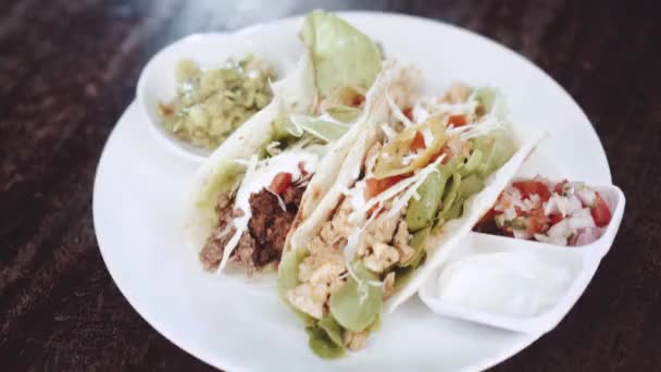 Chicken and cheese and beef tacos served with guacamole, pico de gallo and sour cream dip - video in slow motion - Footage, Video
