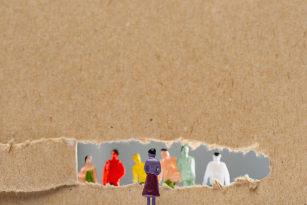 Conceito de direitos sociais com pessoas figuras perto de papelão com buraco isolado em cinza, tiro panorâmico
 - Foto, Imagem