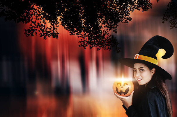 Halloween-Hexe mit magischem Kürbis, Schöne junge Frau mit Hexenhut und Kostüm - Foto, Bild