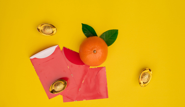 Accesorios en Lunar Año Nuevo y Año Nuevo Chino concepto de vacaciones background.Orange en placa blanca con dinero de bolsillo rojo
  - Foto, imagen