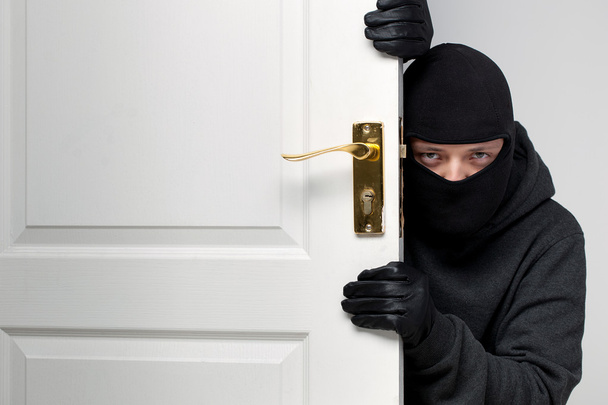 Burglar sneaking in a open house door - Foto, imagen