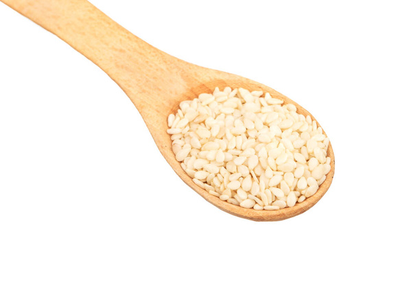 Mała łyżka z nasionami sezamu na białym tle zbliżenie - Zdjęcie, obraz