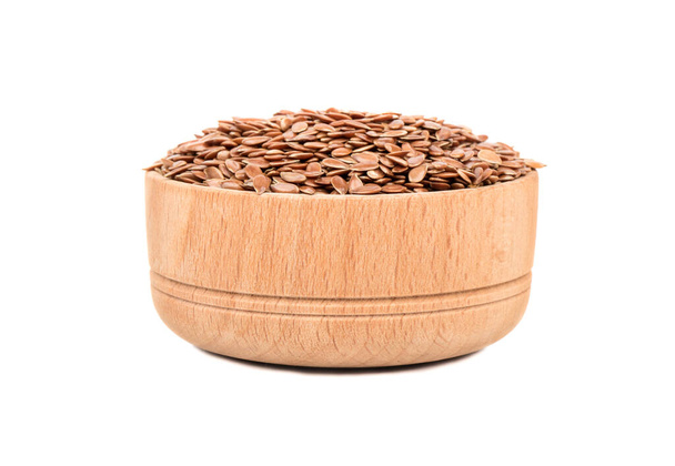 Wooden bowl filled with flax seeds on white background - Photo, Image