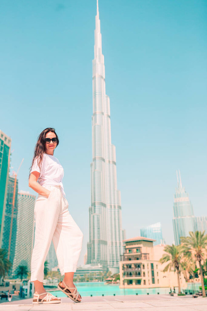 Happy woman walking in Dubai with skyscraper in the background. - Foto, afbeelding